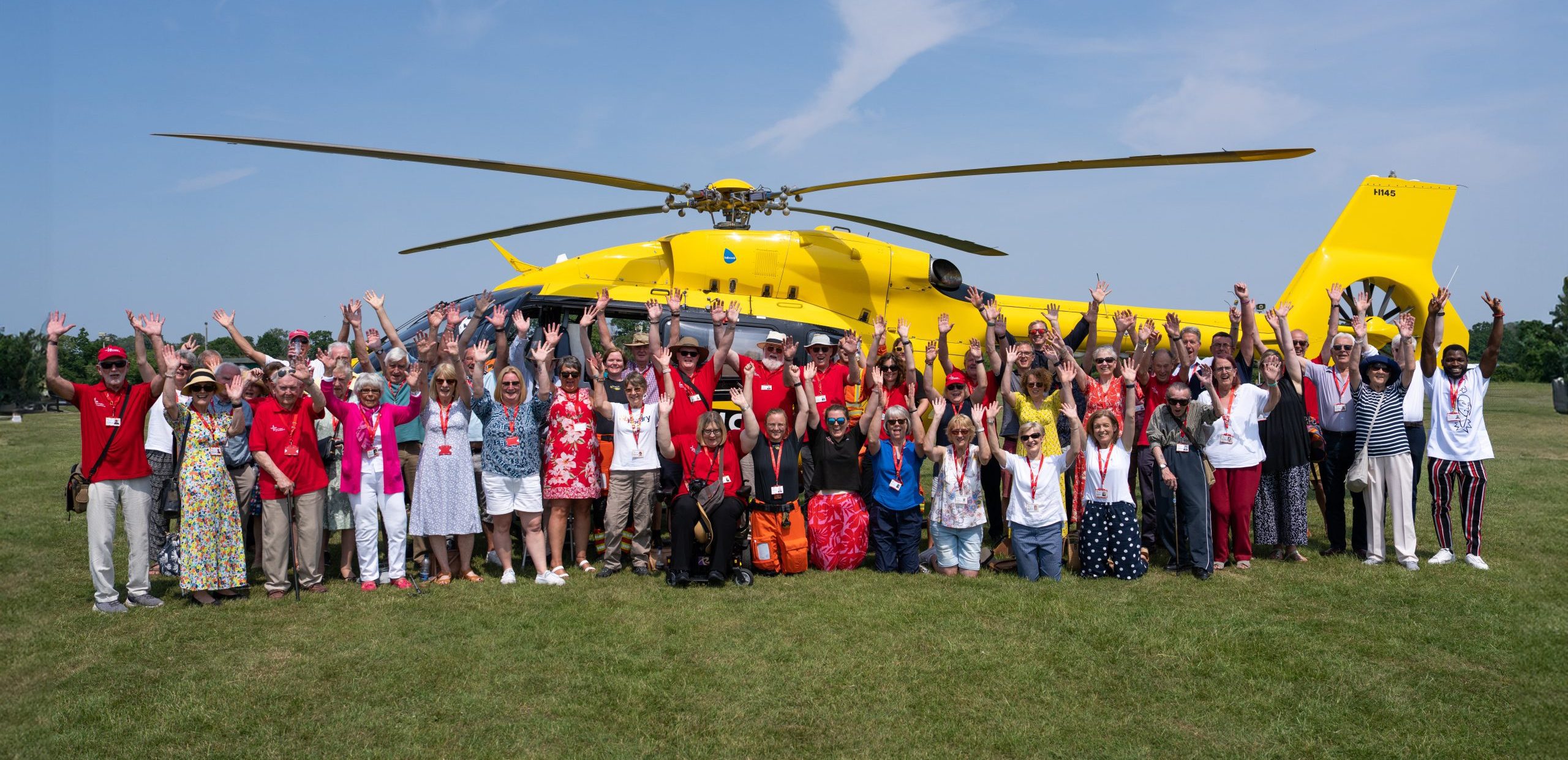 EAAA volunteers standing in front of yellow helicopter