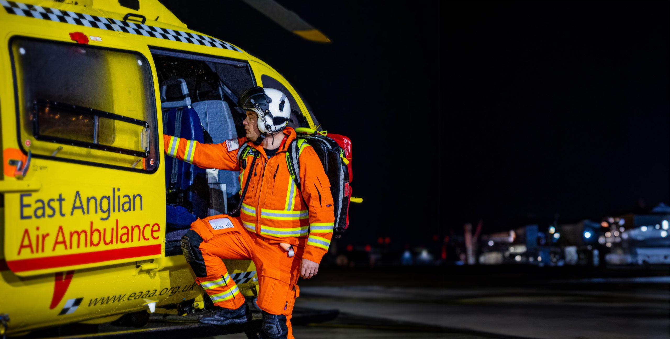 Critical Care Paramedic Josh Davies climbing into Anglia One at night