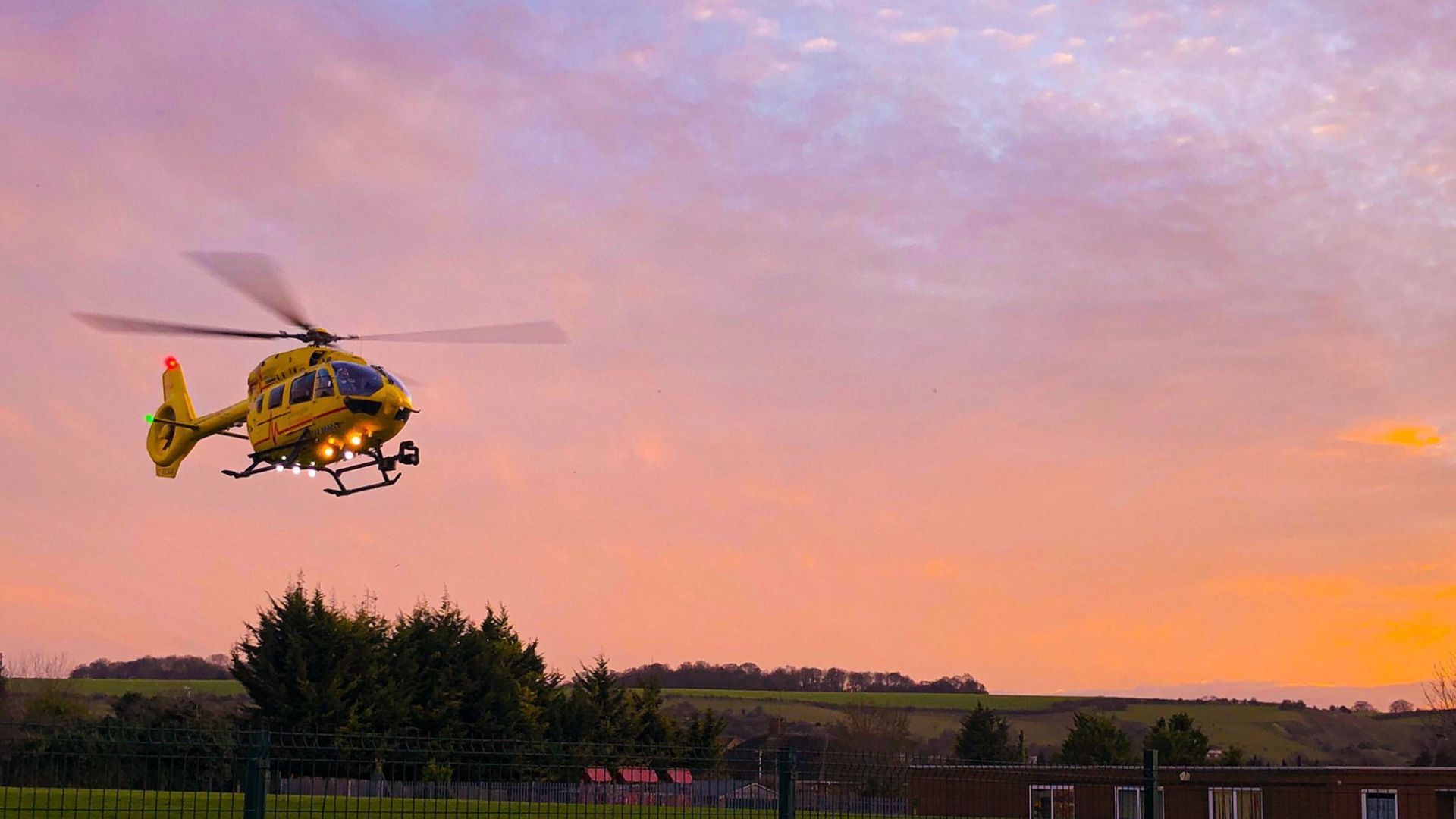 Helicopter landing with pink skies