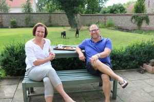 Paul Shattock and his wife Jill sitting on a bench in their garden.