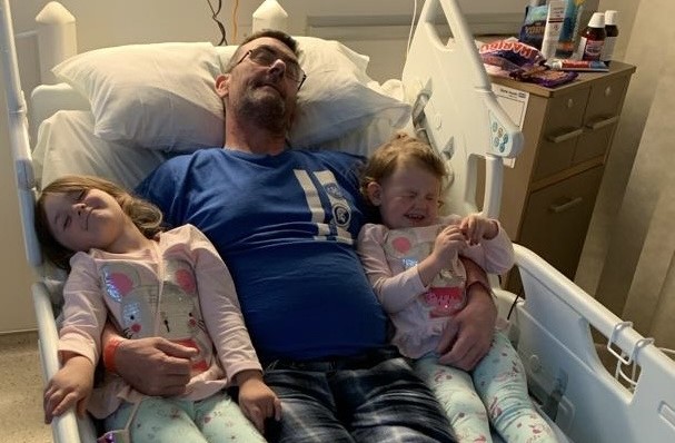 Steve Varney in hospital, with grandchildren.