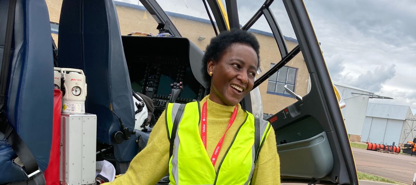 Tope beside the helicopter on a visit to EAAA's Cambridge base.