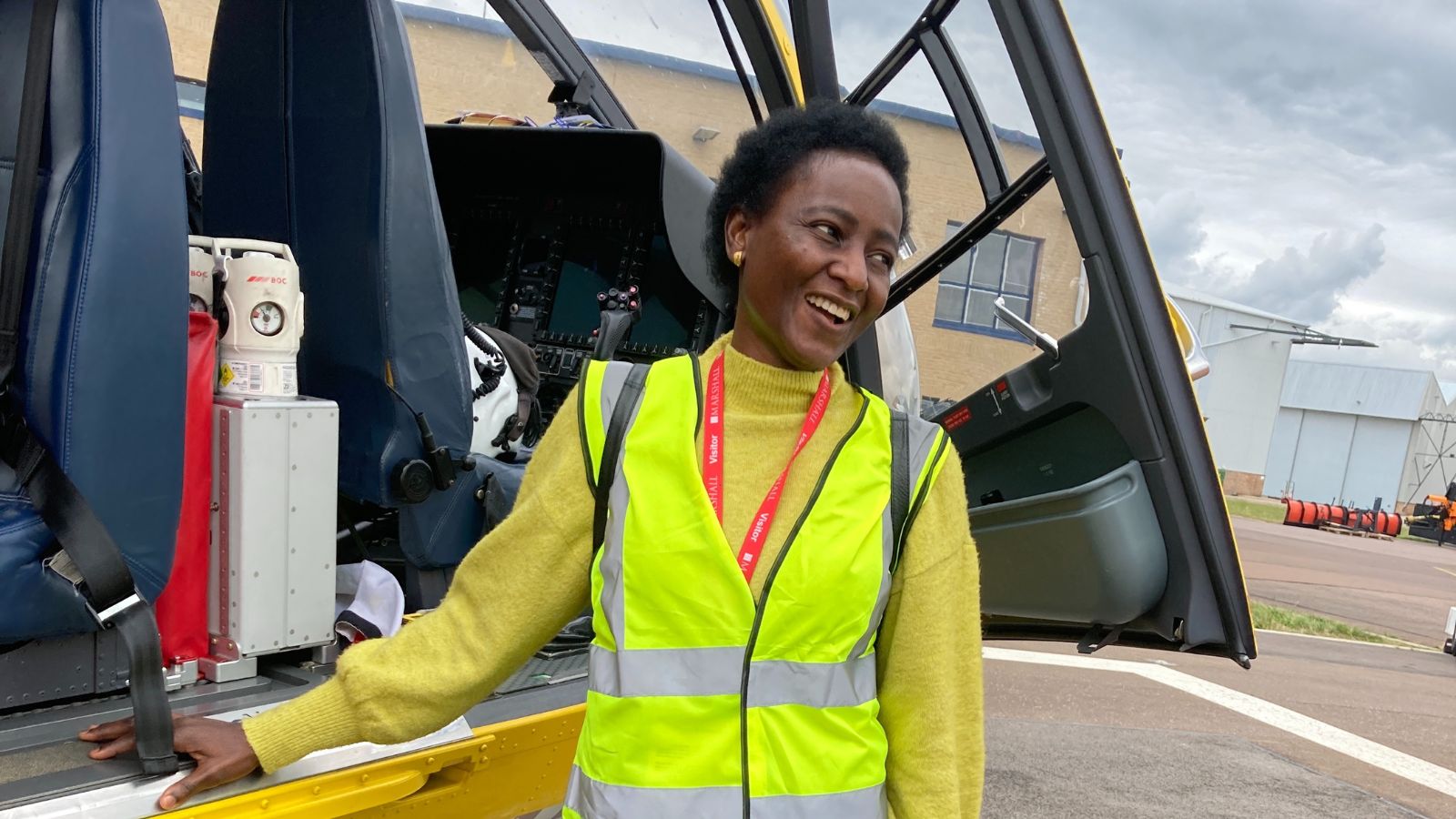 Tope beside the helicopter on a visit to EAAA's Cambridge base.