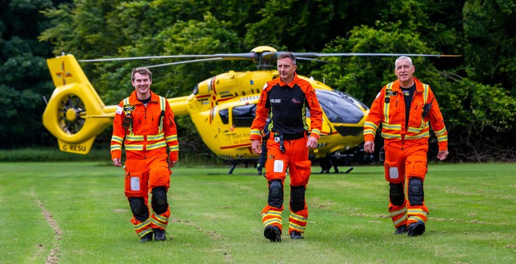 crew walking away from yellow helicopter