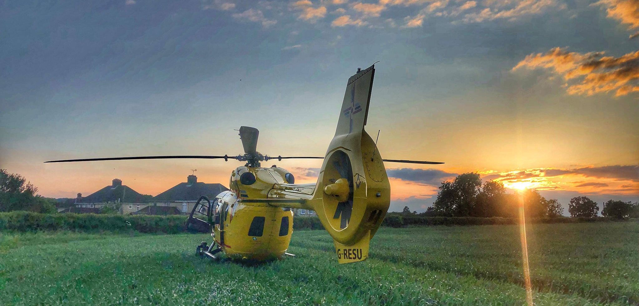 Helicopter in field at sunset