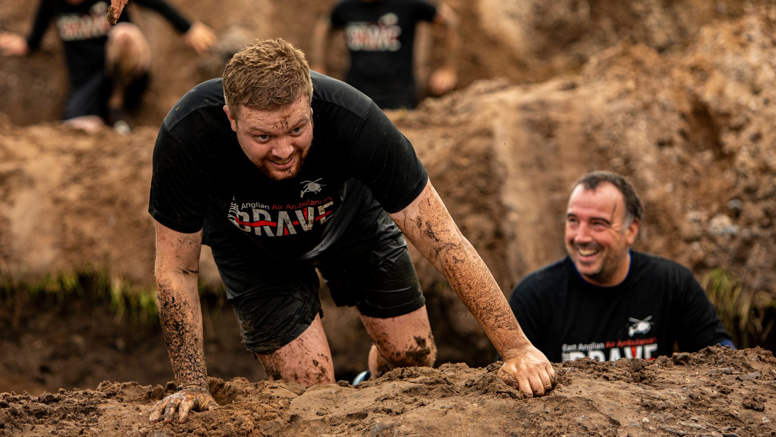 Only the Brave man climbing over mud hill