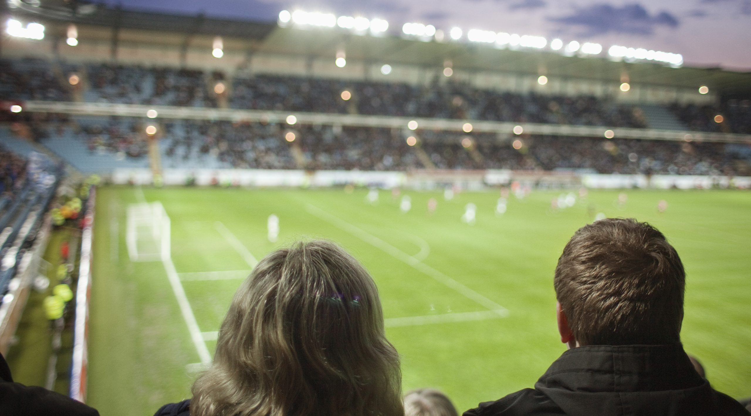 Rear view of people watching football match at stadium