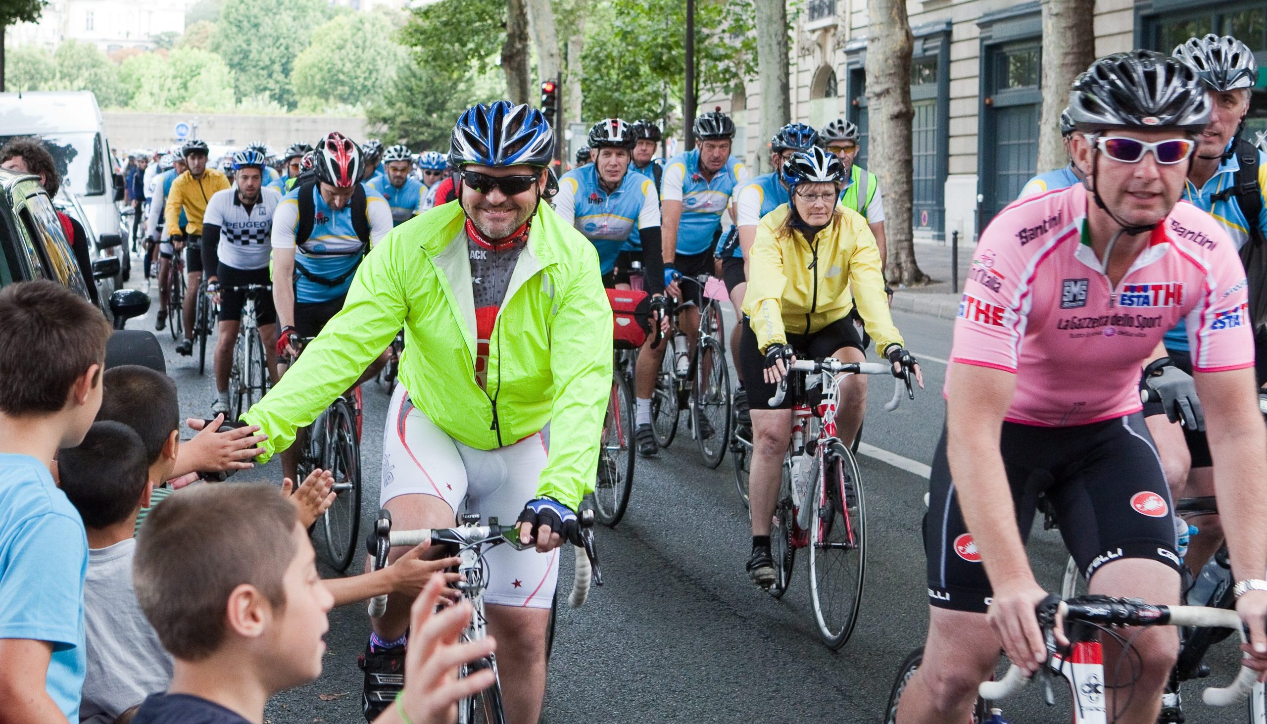 Man high fiving crowd on London to Paris cycle